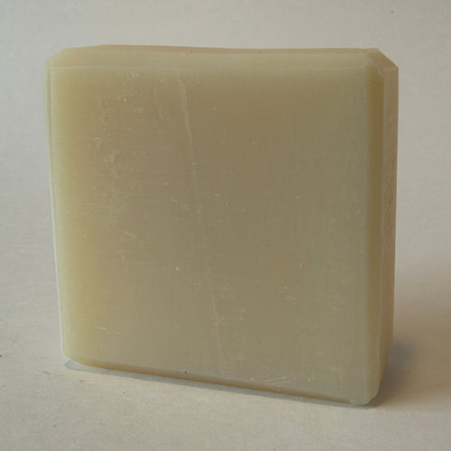 A rectangular bar of creamy off-white soap standing upright on a plain light background.